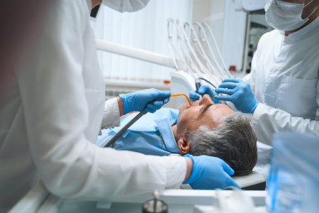 Dentist treating man in his office