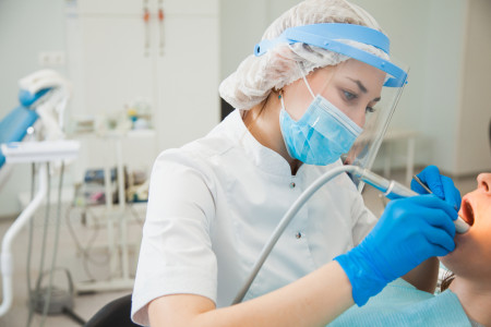 Female dentist curing teeth cavity