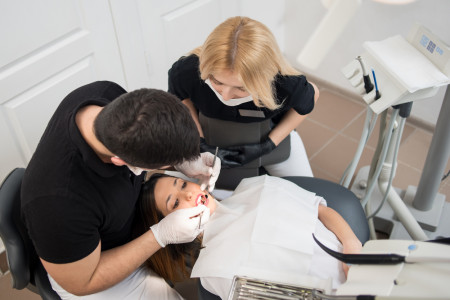 dentist and assistant treating patient teeth