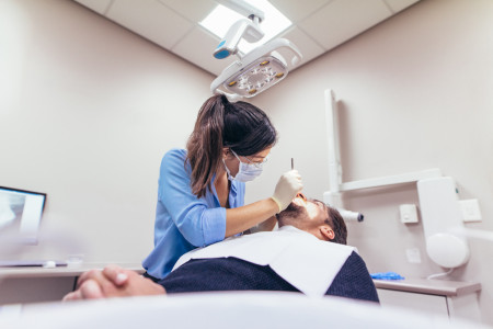 dentist examining a patient with tools