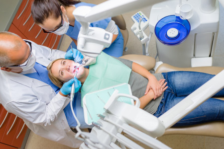 dentist treating patient lying on dental chair